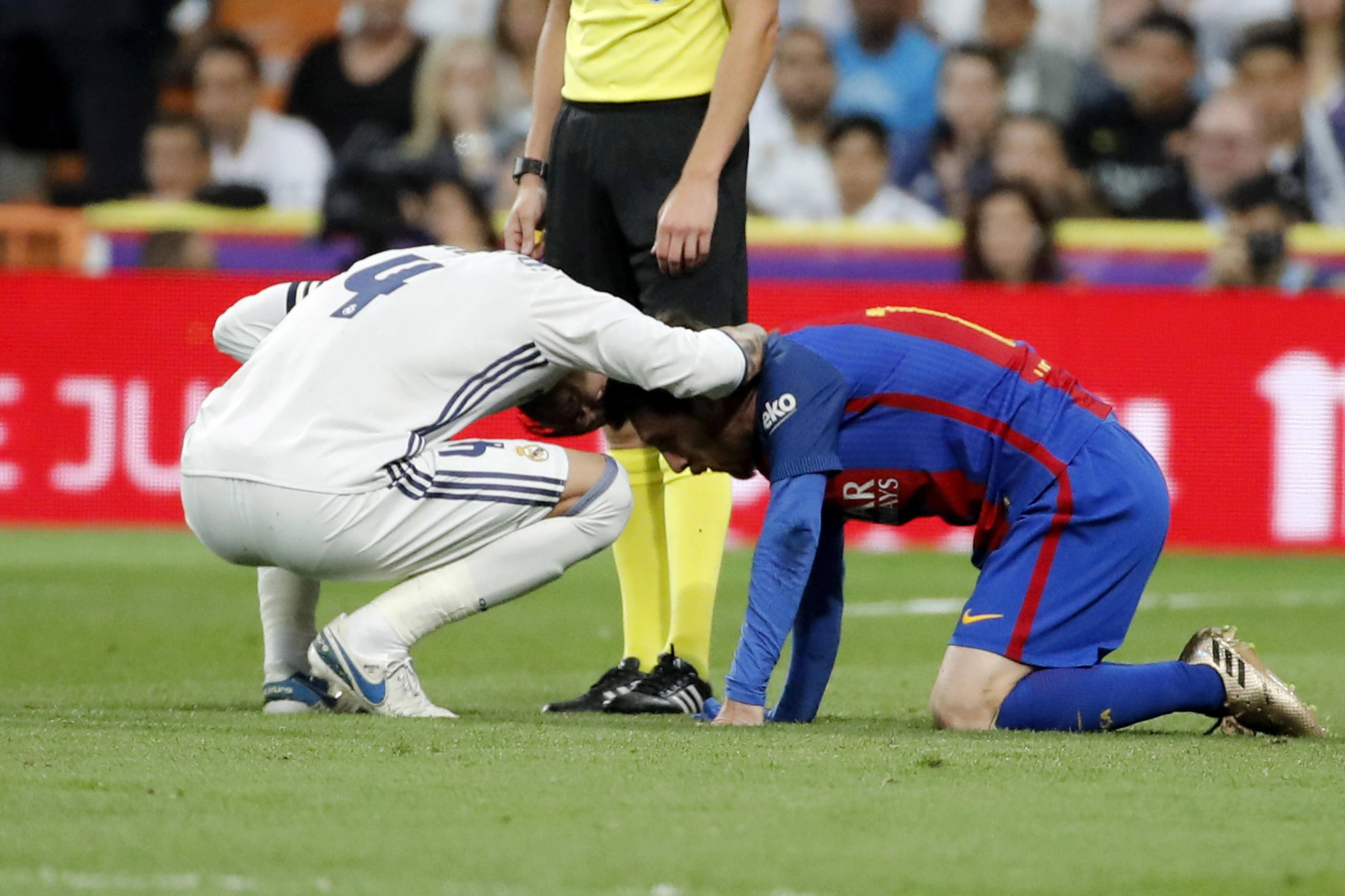 Lionel Messi (dreapta) se resimte după ce a fost faultat de Sergio Ramos. (FOTO: EPA)